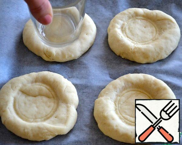 During this time, divide the dough into 12 equal parts (approximately 55 g each), form the cakes and place them on a baking sheet covered with baking paper. Cover with a towel and leave to rise for 30 minutes. Turn the oven to warm up to 190 degrees. Coming up in flour tortillas make depressions (I used the bottom of the glass)...