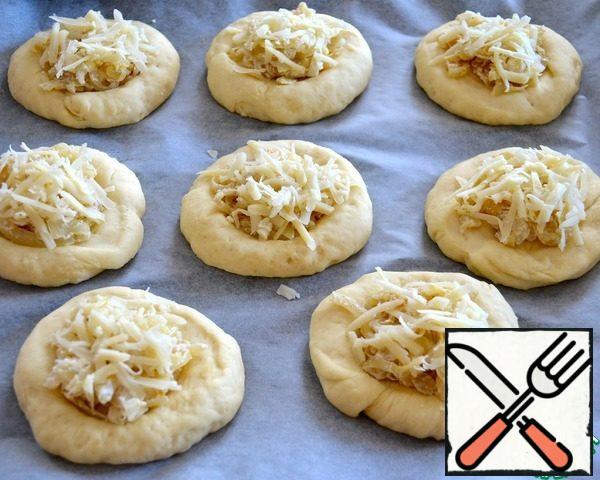 Place the filling in the hollows in the cheese buns and sprinkle with grated cheese on top.