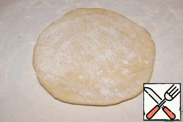 Get the dough out of the refrigerator and roll out placing between two sheets of baking paper sprinkled with flour, in a circle 32 cm in diameter.