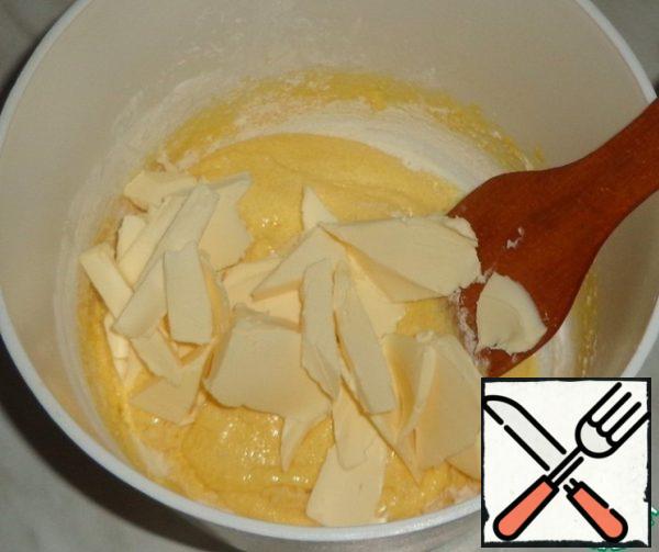 Cut the softened butter into small pieces, add to the dough and whisk.
