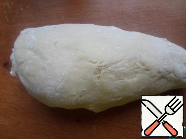 Add to the resulting mass of flour (how much will take the dough), knead the dough so that it does not stick to your hands.