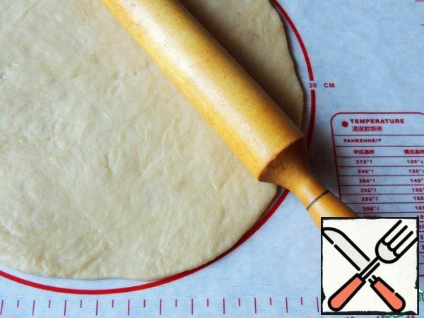 Roll out the dough to a diameter of 30 cm, trying to make the edges thinner. Next, the cake can be formed directly on parchment (the biscuit acquires a free form). I baked a cake in a silicone mold with a diameter of 24 cm.
