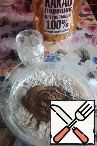 Make the dough. To do this, slightly whisk 1 egg with 1 Cup of sugar and a pinch of salt. Add half a can of condensed milk and a glass of kefir (sour cream) at room temperature. On kefir-half of the required amount of soda. Mix and add 1 Cup of flour, 2 tablespoons of cocoa (I add cocoa with flour to avoid lumps), and the remaining soda.