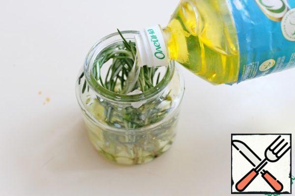 To prepare the filling, we will need fragrant rosemary oil. In a clean jar, add rosemary and garlic cloves, pour vegetable oil. This oil can be stored for a long period.

