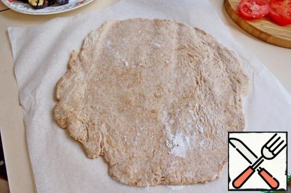 Remove the dough from the refrigerator and roll into a round layer, 0.5 mm thick.