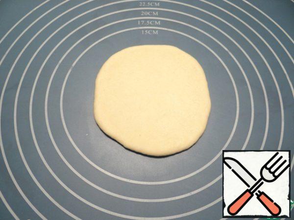 The dough for the bottom is rolled into a circle.