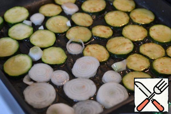 Zucchini cut into slices.
Add sunflower oil to the pan.
Spread the pieces of zucchini and grill until pink, turn and add the onion.
