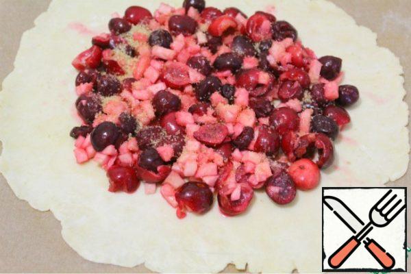 Roll out the dough between the films in a circle and transfer to parchment.
Sprinkle the bottom lightly with starch and lay out the filling, not reaching the edge 2-3 cm.