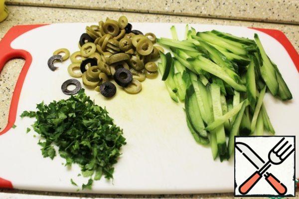Cut the cucumber thinly across, then strips, olives and olives - rings, parsley - finely.