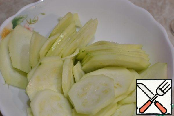 Peel the zucchini, cut into thin circles, add a little salt, sprinkle with a universal seasoning.
