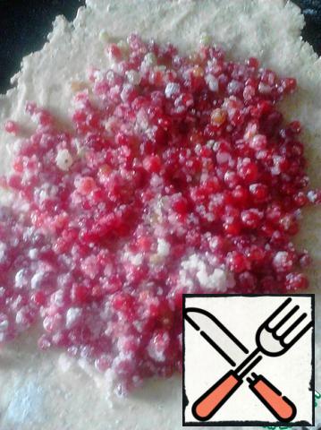 Currant touch, wash, dry.
Add sugar, starch. Stir.
Remove the dough from the refrigerator, roll out into a thin layer, put the rolled dough on a baking sheet, oiled.
Put the berry filling, leaving the edges free.