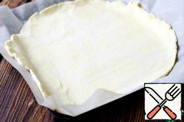 Roll the dough into a ball, sprinkle it with flour and roll it into a circle on parchment.