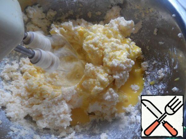 Eggs pour in small portions into a mixture of margarine and sugar.
