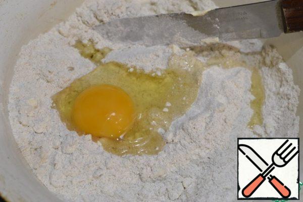 We prepare the dough. Sift 2 types of flour, mix with salt and sugar, add cold butter and grind into fine crumbs. Add milk and egg.
