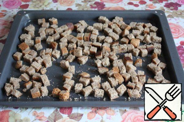 Cut the black bread into cubes and dry it in the oven at a temperature of 220 * C for 15-20 minutes.
