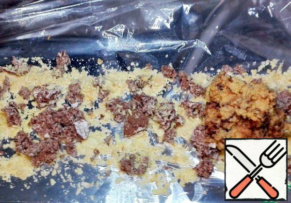 We lay out the foil on the table, cellophane on it. I poured out the crushed petals and broke the waffles.
Put the mass of millet on top, spread over almonds and waffles.

