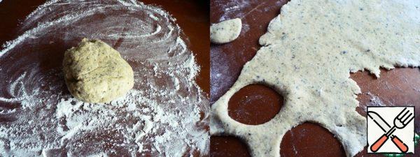 After the time, sprinkle the table with flour and roll out the dough. Cut small circles.