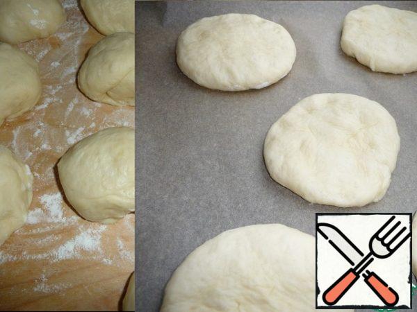 Divide the dough into 10 pieces of 76.5 g, round them off and leave them alone for 10 minutes under the film, then roll the dough into a flat cake and put it on a baking sheet covered with baking paper at a distance from each other, cover with a film and leave for 15 minutes to stand up.
