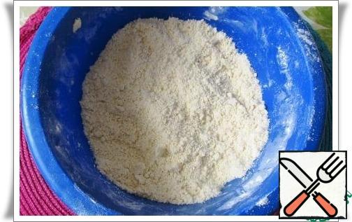 Prepare the flour mixture: mix the flour in a bowl with baking powder, add the pieces of butter at room temperature and grind with your hands into small crumbs.
Turn on the oven to heat up to 175 degrees C.