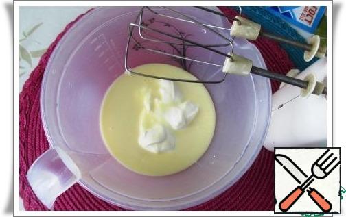 While the cheesecake is baking, prepare the sauce.
Mix with a mixer sour cream and condensed milk.
Can be add in pouring any flavor: essence, lemon zest, cognac and anything.