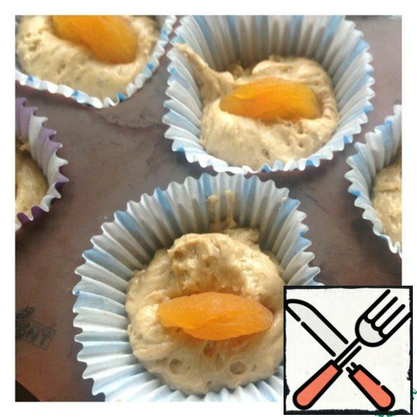 Put the dough into the molds. Dried apricots are not pre-soaked. Place 1 piece of dried apricots in the center of the cupcakes until the end of the molds. Place the cupcakes in the oven at 180 degrees until ready (15-20 minutes).

