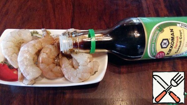 Peel and marinate the shrimp in soy sauce.
