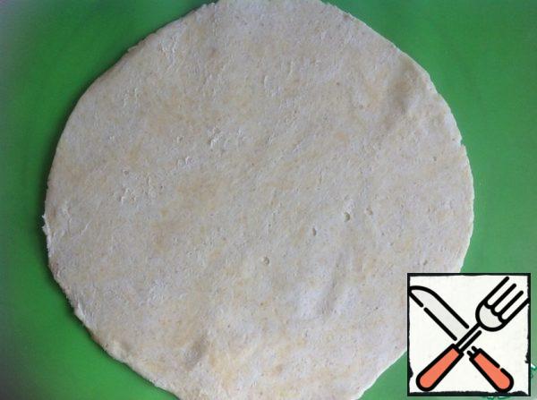 Roll out the cooled dough on a floured surface. I'm rolling it right out on a silicone Mat, which I'm going to bake on. In this case, there is no need to transfer the biscuits on a baking sheet. Therefore, I advise you to roll out either on a silicone Mat or on parchment.