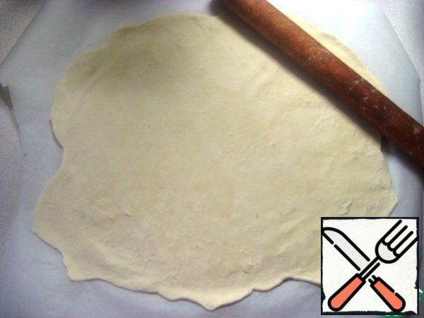 Roll the cooled dough on a sheet of baking parchment into a thin layer.