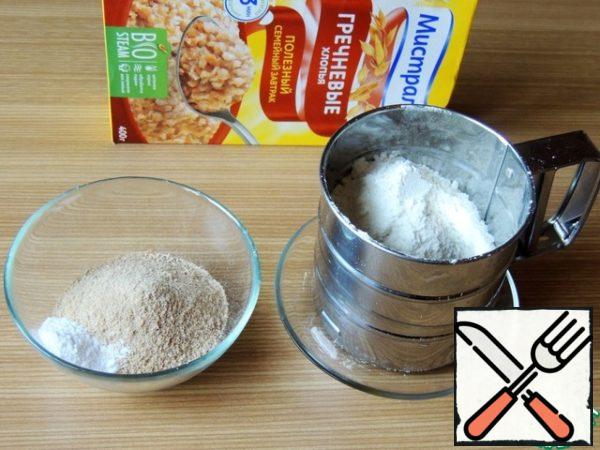 Grind buckwheat flakes in a coffee grinder to the state of flour. Mix and sift buckwheat and wheat flour with soda.
