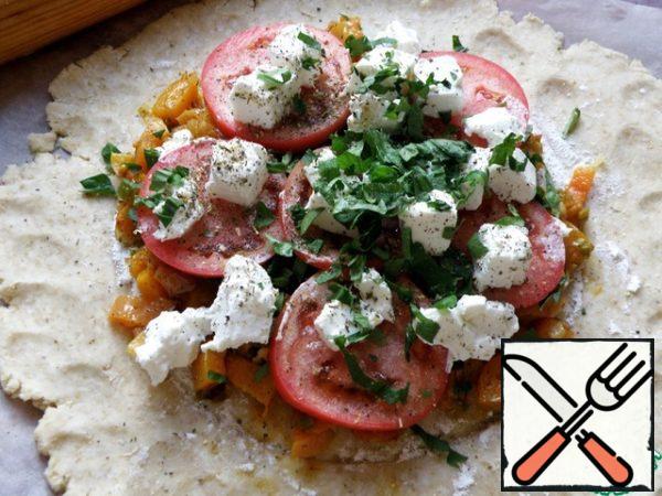 Lay out the pumpkin filling, put thin slices of tomato, cubes of soft cheese and chopped greens on top. You can take cheese with mold or cheese.
