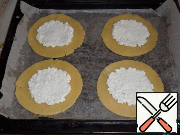 Spread the cakes on a baking sheet covered with parchment. Spread the curd filling on the cakes and spread evenly, not reaching the edge of 1 cm.