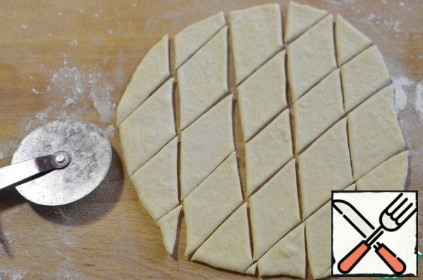 While the cheesecakes are in proofing, I'm making decorations. Leaves: roll out a layer of dough, cut it into small lozenges with a pizza knife. There is no such knife, take a spatula or an ordinary sharp knife.