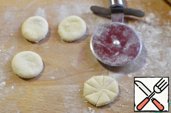 I cut out circles from the dough, if there is nothing to cut, then roll out a less smooth circle, with a pizza knife I make cuts in segments (about 10), without cutting through the center.