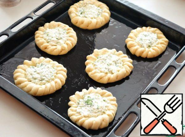 Place the cheesecake blanks on a greased baking sheet. If desired, brush the buns with egg.
Fill them with filling and leave for 15-20 minutes to rise.