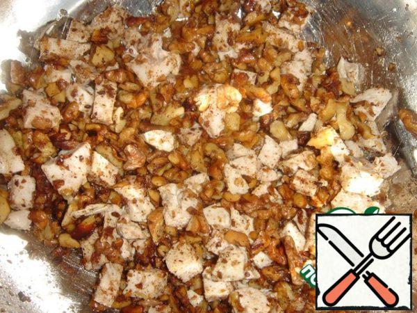 Add the nuts to the chicken along with the oil in which they were fried, mix.
