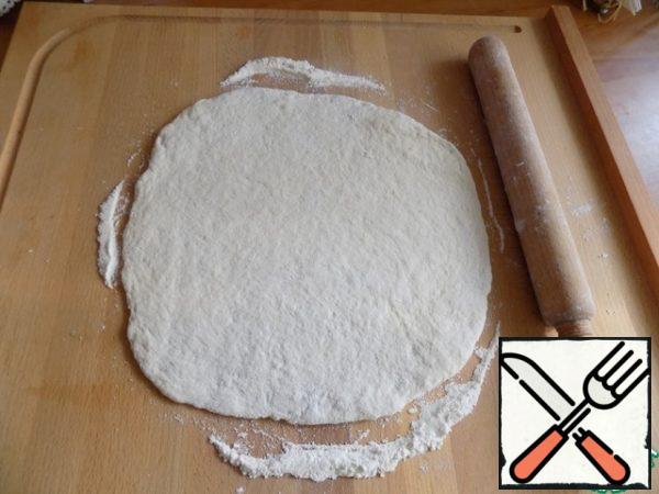 Roll out the layer about 0.7-1 cm. I use a pizza baking dish D-24 cm. That's the same diameter I roll out the dough.
