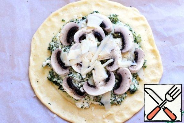 Preheat the oven to 200 degrees. Remove the dough and spread the filling. Lay out on top of thin slices of fresh mushrooms. Put thin slices of Parmesan over them.
