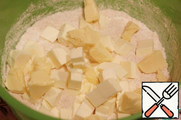Cut the butter into cubes, add it to the dry mixture and rub it into crumbs with your fingers or chop it with a knife. Do not do this too carefully, it will be even better if small pieces of butter remain in the dough.
