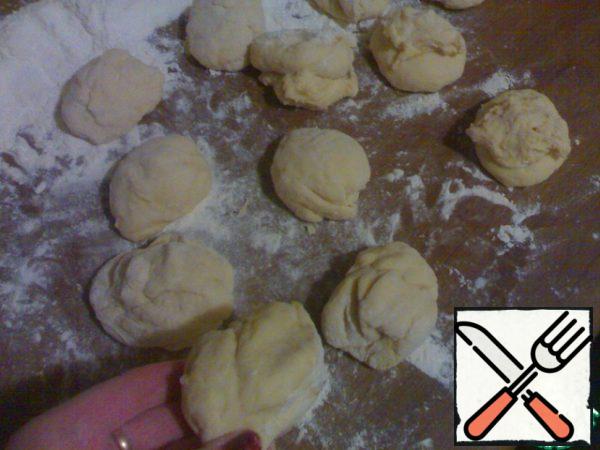 Put the finished dough on a floured table (I had 1 cup), form a sausage and divide into 12 equal parts.
From each part, make flattened balls, put them on a greased baking sheet and cover with a towel so that they increase two to three times.
