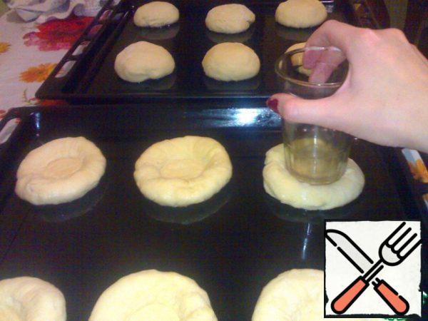 As the balls came up, take a glass and press the bottom in the middle. Put cottage cheese in the middle. Cover with towel..
Turn on the oven at 200 degrees and allow to heat up completely! During this time, the cheesecake will grow more!