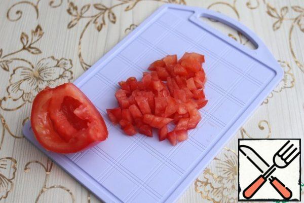 Cut the tomato into two parts, remove excess moisture and seeds. Cut the tomato cups into small cubes.
