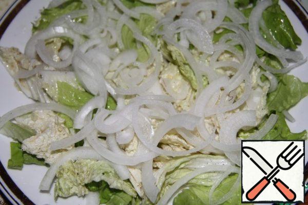 Put lettuce (tear with hands), Chinese cabbage and sprinkle with half rings of onions on the dish. Add half of the salad dressing and mix.