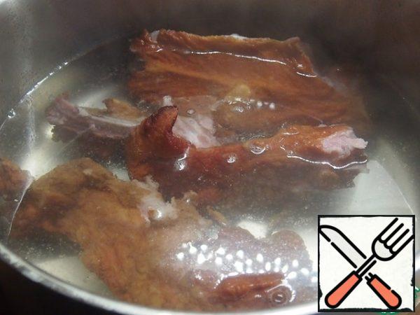 Pork smoked ribs pour water and cook for 40 minutes. The ribs are ready remove from the saucepan, separate the meat from the bones and cut the meat into pieces. Bones throw away.