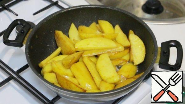 Then fry large slices of potatoes in the same oil under a closed lid. Stir occasionally and do not forget to add salt. Use a fork to check the readiness of the potatoes. We put the finished potatoes on a separate plate.
