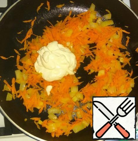 Onions cut into small pieces, carrots grate on a large grater. Fry the onion in vegetable oil until transparent, add carrots. Fry for a couple of minutes.
Add sour cream or mayonnaise, stir and heat well.