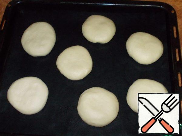 Roll 7 pieces into a ball, give a flattened shape and place on a baking sheet at a distance from each other. Cover with polyethylene and leave for 15 minutes. Divide the remaining piece of dough into 7 parts and use for decoration. This dough is also covered with polyethylene or a towel.