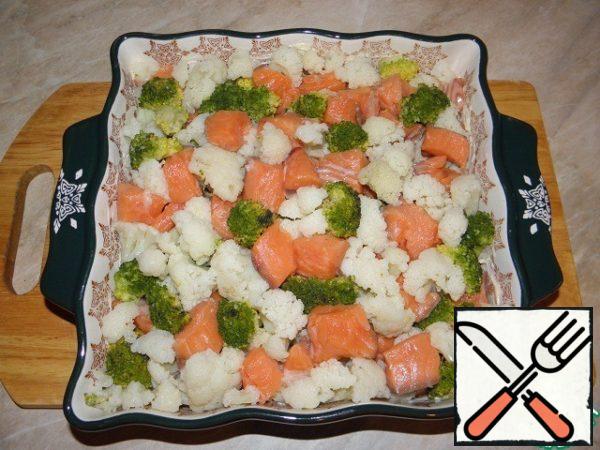 Grease a baking dish with high sides with butter, put boiled cauliflower and broccoli, as well as fish in a mold.

