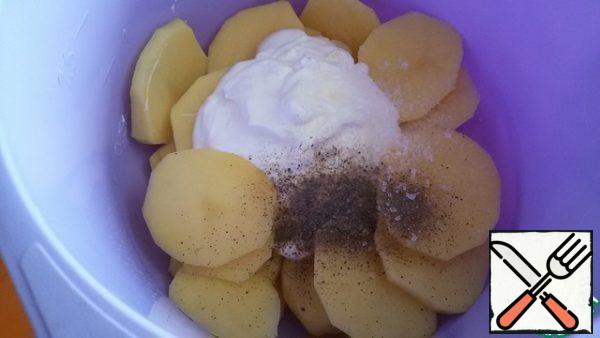 Peel potatoes, cut into slices 5-6 mm thick. Add 2 tablespoons of sour cream, salt and black pepper.