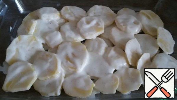 The bottom of the baking dish ( the size of my forms 33 to 20 cm) grease with vegetable oil. Put potatoes in sour cream.