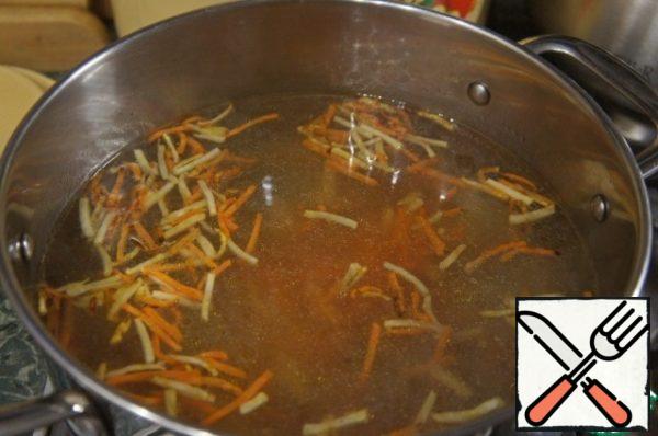 Lower the fries into the boiling broth.